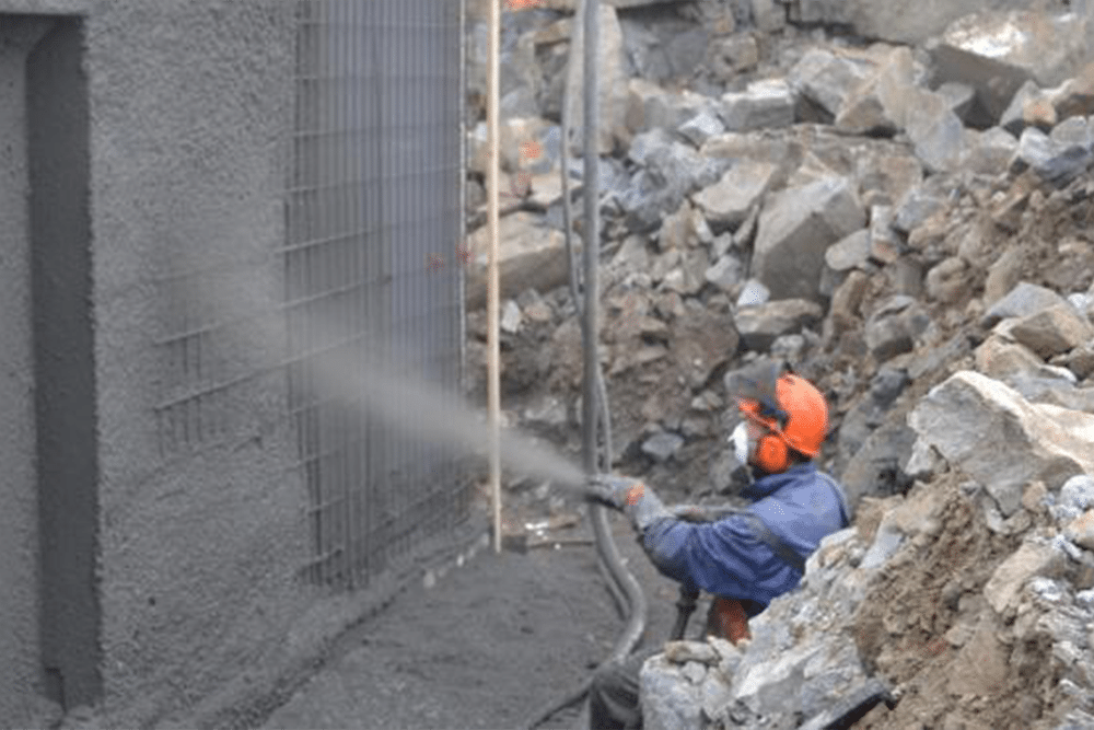 Mann sprayer betong på vegg